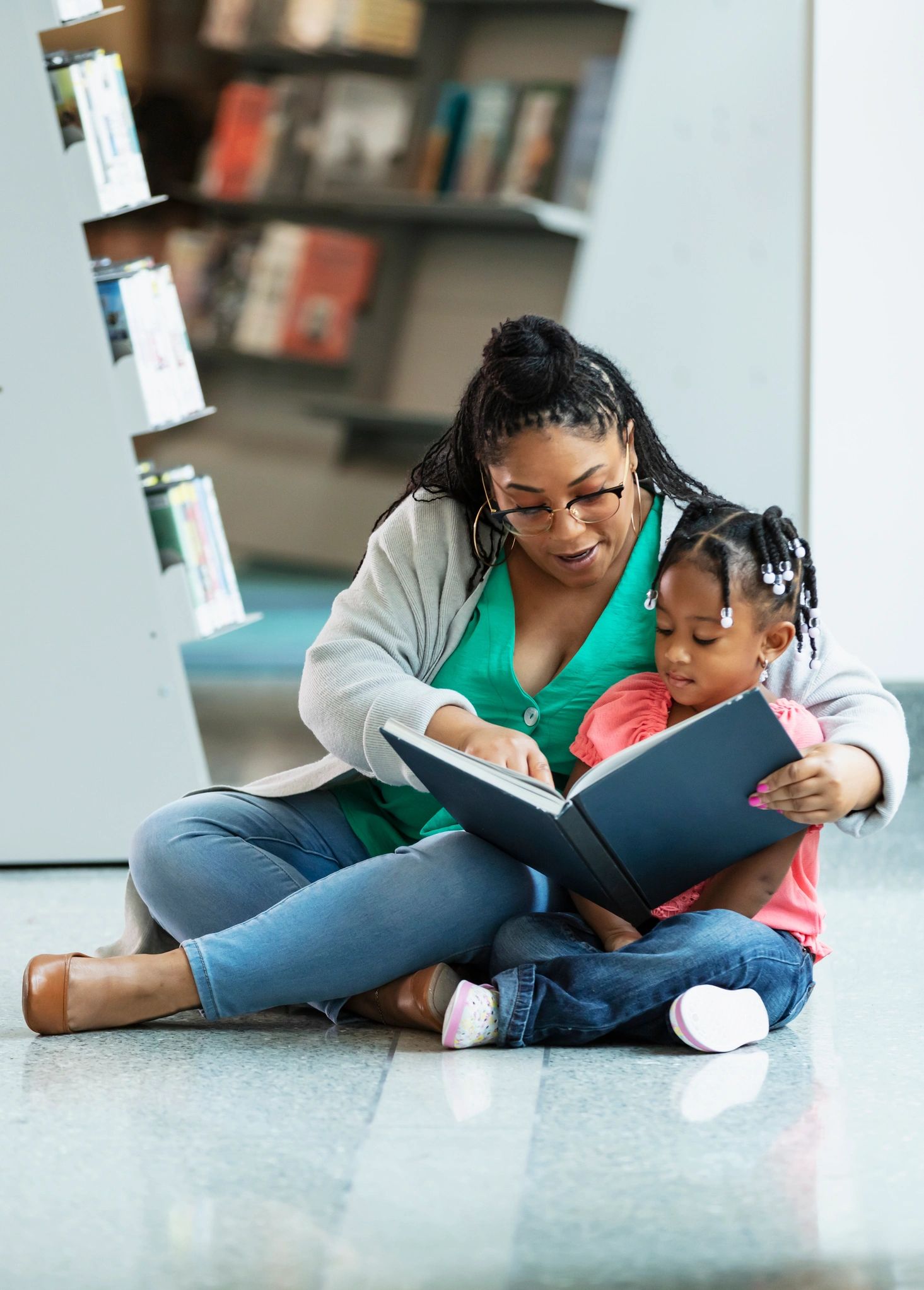 Mother and child reading together in a library