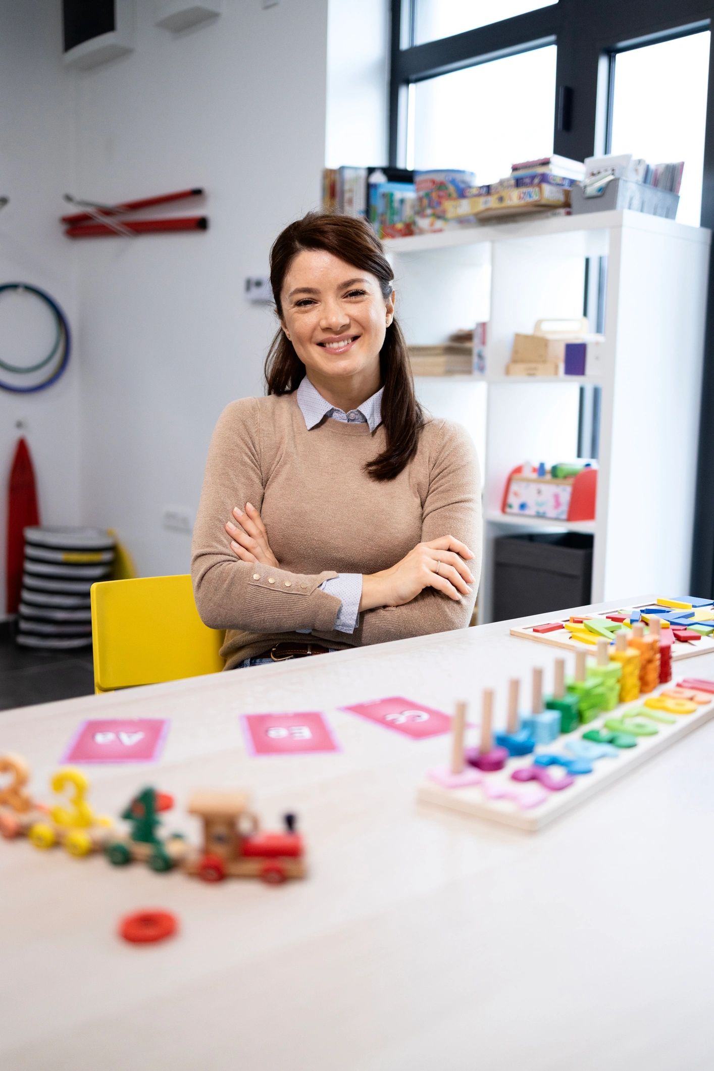 Educator smiling in a classroom with learning materials