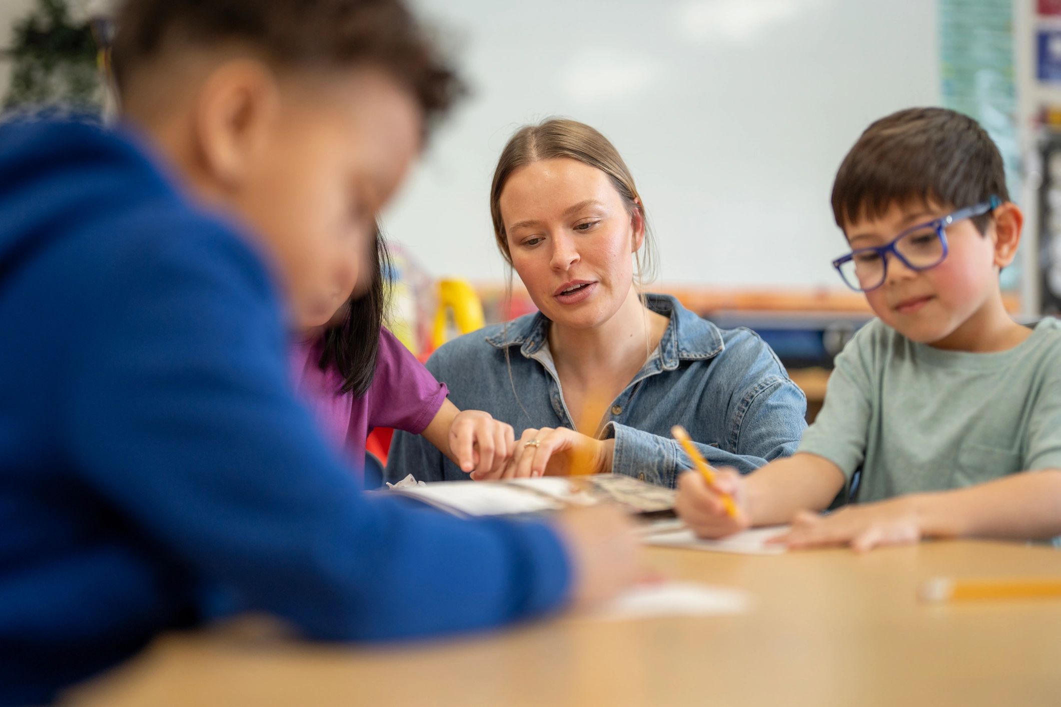 Teacher helping children with a classroom learning activity