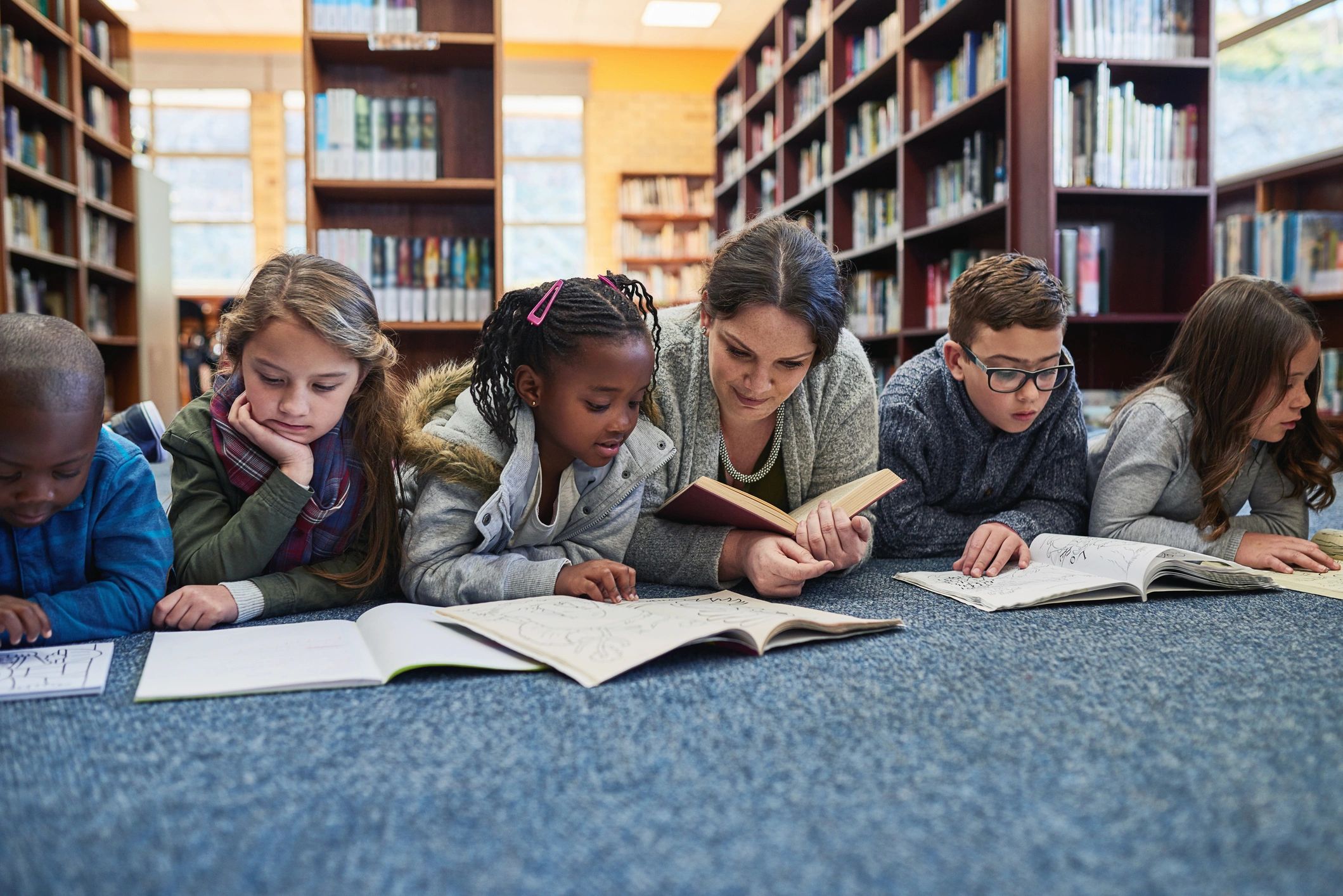 Teacher and children learning together in a library